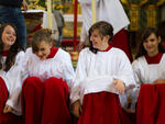 Ministrantinnen sitzen auf der Altarstufe und lachen.