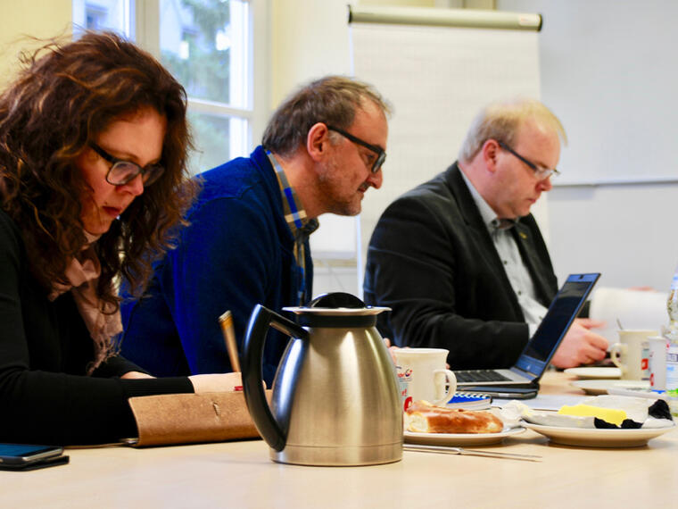 Personen der Steuerungsgruppe sitzen am Tisch