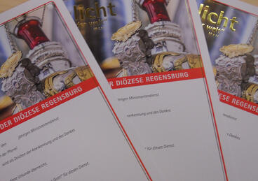 Auf einem Tisch liegen drei Ministrantenurkunden.