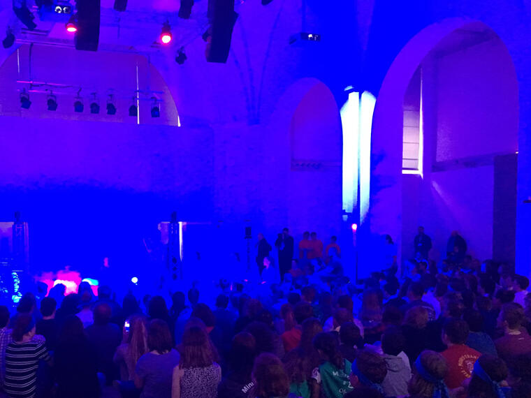 Eine in blaues Licht getauchte Kirche. Jugendmaiandacht mit 500 Jugendlichen in München.