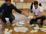 Fachstellenleiter und eine Arbeitskreis Mitarbeiter sortieren die verschiedenen Ideen, die die Hauptamtlichen auf Wortkarten geschrieben haben.