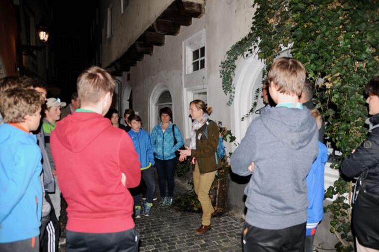 Jugendliche hören der Stadtführern zu