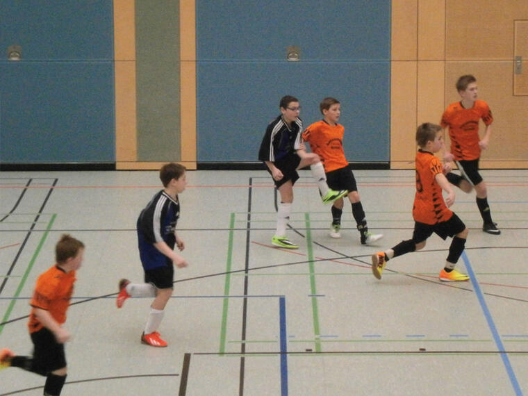 Ministranten spielen Fußball in einer Halle.