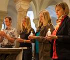 Gruppe an Altar mit Kerzen in Händen