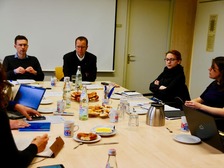 Personen der Steuerungsgruppe sitzen am Tisch